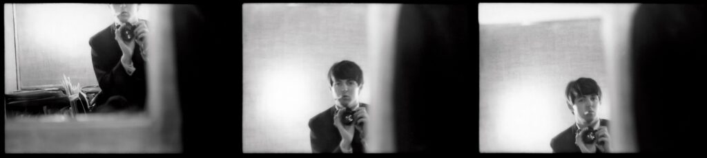 Paul McCartney of The Beatles taking a picture of himself in a mirror in 1963